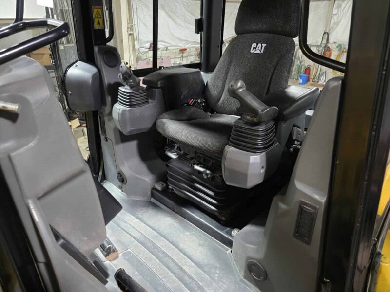 Indoor view of the operator's seat and controls in a 2020 Caterpillar D6K2 bulldozer.