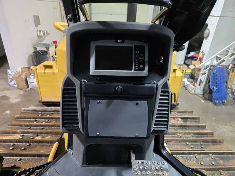 Control panel of a 2020 Cat D6K2 bulldozer with digital display and operational controls.
