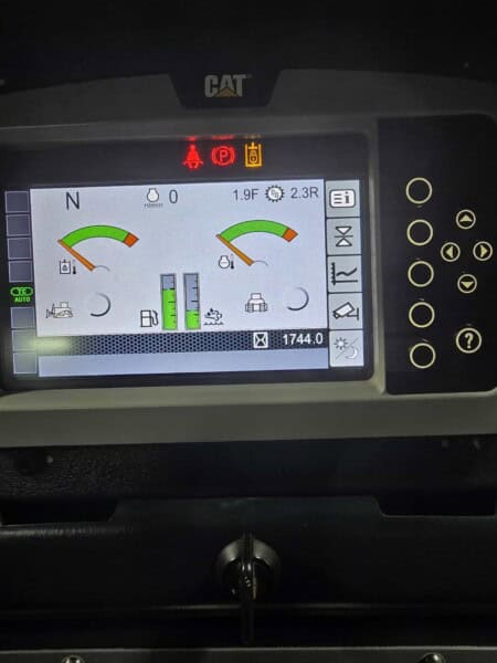 Digital display panel of a 2020 Cat D6K2 bulldozer showing operational gauges and warning lights.