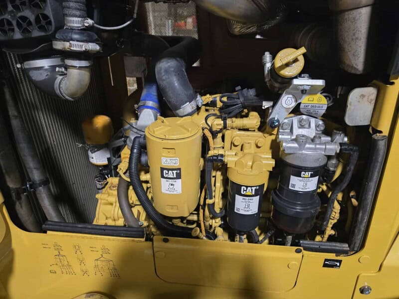 Close-up of engine components on a 2020 Caterpillar D6K2 bulldozer showing filters and hoses.
