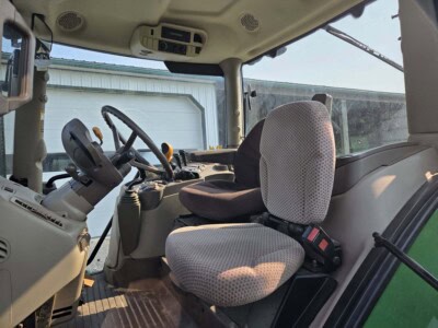 Interior view of a John Deere 6125R tractor cab with control panel and seating.