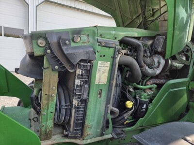 Close-up of green John Deere 6125R tractor engine and radiator area.