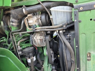 Close-up of engine components in a green John Deere tractor 6125R.