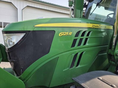 John Deere 6125R green tractor with black grille and yellow branding, front view.