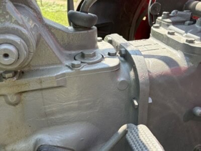 Close-up of Massey Ferguson 50 tractor engine with visible gear shift and foot pedal.