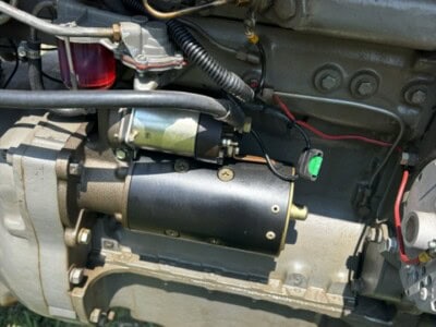 Close-up of engine components on a 1963 Massey Ferguson 50 tractor showing wiring and mechanical parts.