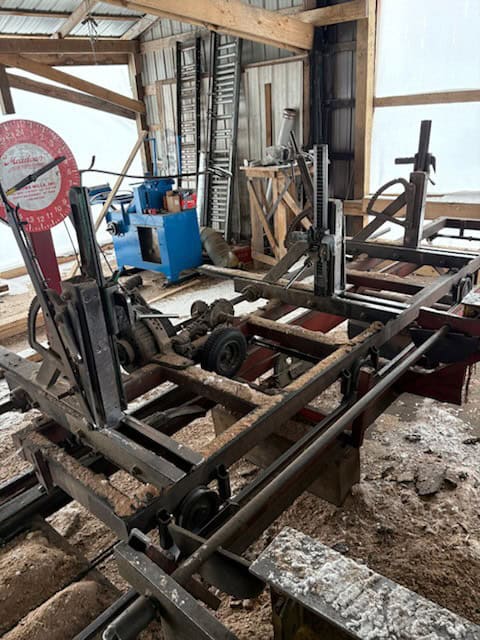 Heavy-duty metal frame with various mechanical components in a workshop setting.