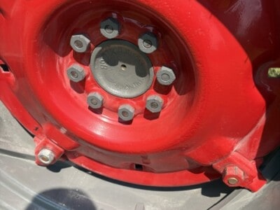 Close-up of Massey Ferguson 50 tractor wheel with red rim and lug nuts.