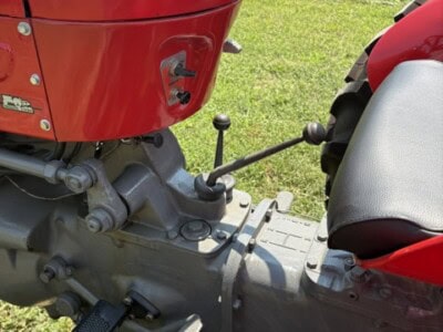 Close-up of Massey Ferguson 50 tractor dashboard and steering wheel with gear shift lever.