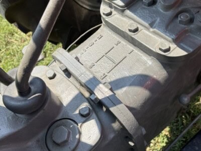 Close-up of Massey Ferguson 50 tractor transmission with gear shift and engine components visible.
