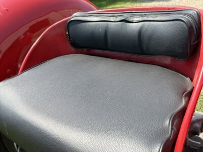 Close-up of Massey Ferguson 50 tractor seat with backrest and steering wheel in background.