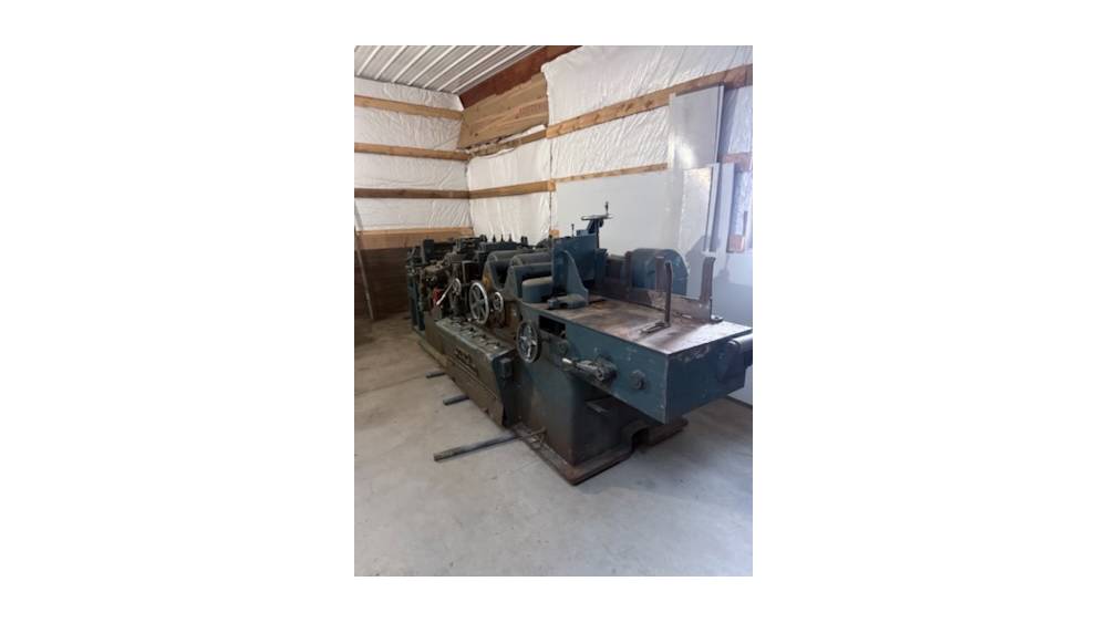 Industrial metalworking lathe machine in a workshop setting.