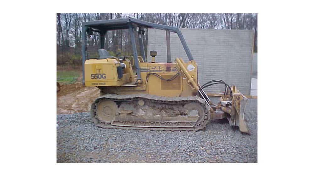 Caterpillar 550G compact track loader with blade attachment, yellow, used for construction and landscaping.