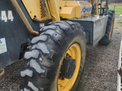 Heavy-duty yellow and black construction equipment, likely a loader or telehandler, with large tires and "GEHL" branding visi.