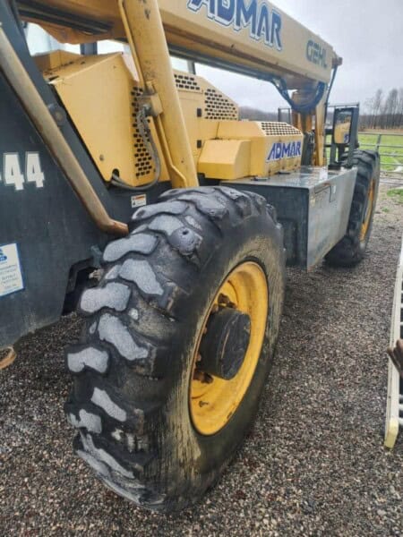 Heavy-duty yellow and black construction equipment, likely a loader or telehandler, with large tires and "GEHL" branding visi.