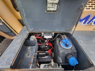 Open engine compartment of 2017 Gehl RS8-44 compact loader showing battery and fluid tank.