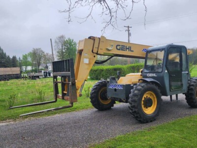 2017 Gehl RS8-44 telehandler with extended boom and forklift attachment on a gravel path.