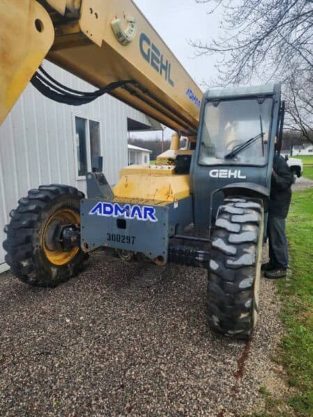 All-terrain telescopic boom lift, 2017 Gehl RS8-44, with yellow and black construction equipment, parked outdoors on gravel s.