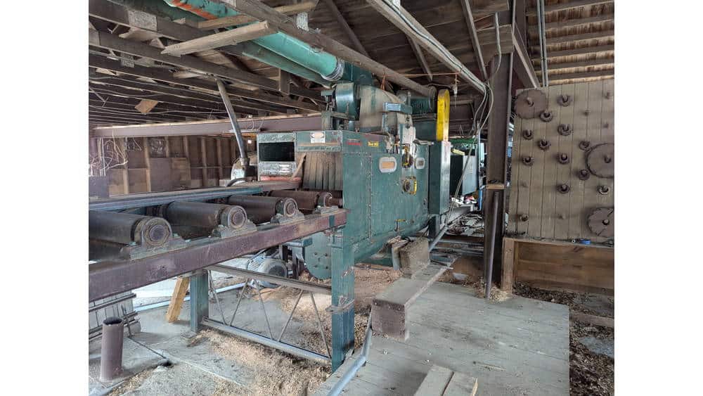High-capacity industrial woodworking machine in a rustic workshop setting.