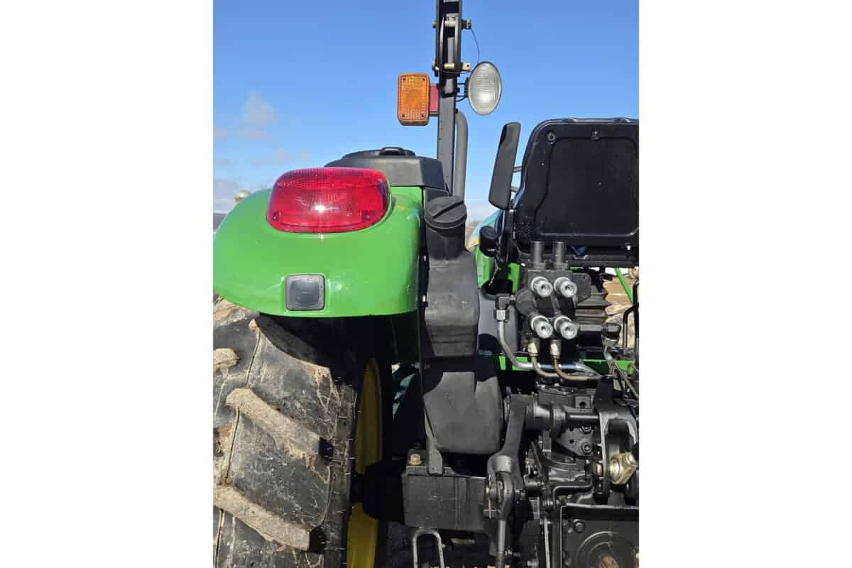 John Deere 5075E tractor with rear hydraulic system and large rear tire.