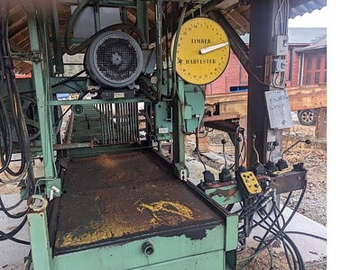 Industrial green and yellow machinery with control panel and hoses, used for manufacturing or processing tasks.