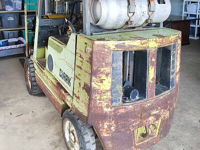 Clark forklift with propane tank, vintage model, used for material handling in a warehouse environment.