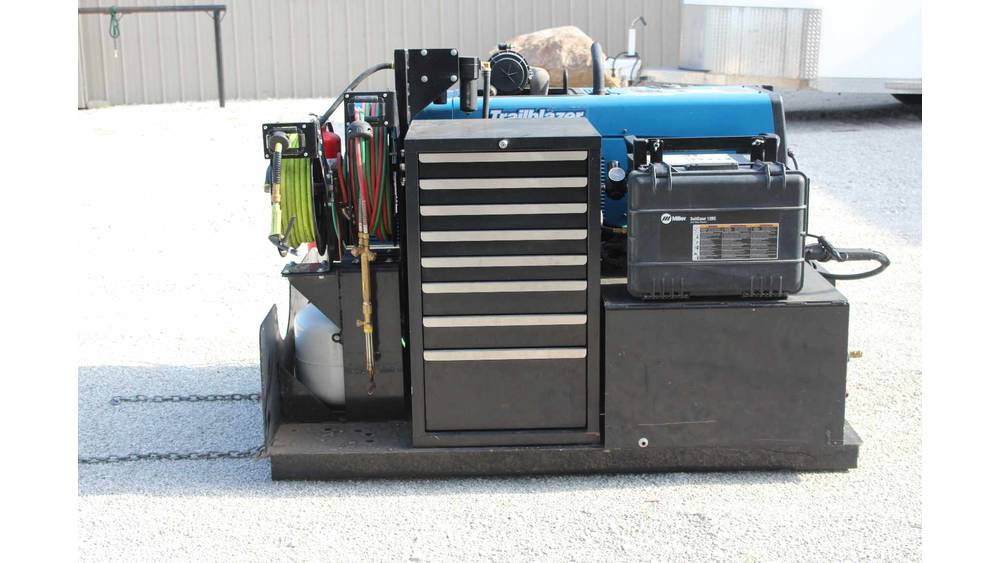 Portable industrial generator with blue and black casing, equipped with tools and control panel.