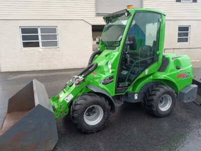 Green Bobcat T595 compact loader with bucket attachment, suitable for construction and landscaping tasks.