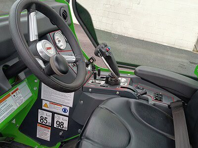 John Deere Gator utility vehicle interior with dashboard, steering wheel, and black seat.