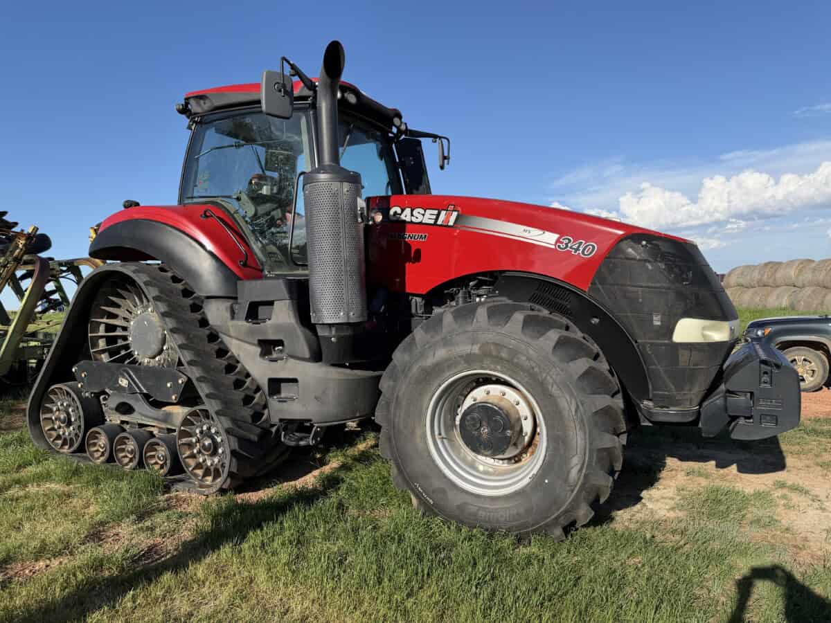 2016 Case IH Magnum 340 tractor with cab and track system on grassy field.