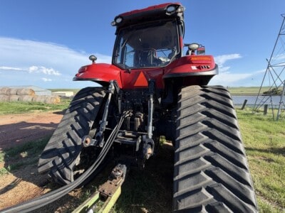 Red 2016 Case IH Magnum 340 tractor with large tires and enclosed cab on farm field.
