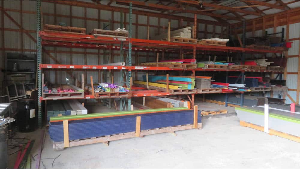 Heavy-duty shelving units with various building materials stored inside a warehouse.