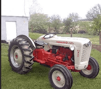 Vintage 1950s Massey Ferguson 35 tractor with red and white color, large rear tires, and open operator seat.