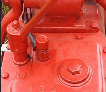 Vintage red tractor engine with a Mickey Mouse-themed steering wheel.
