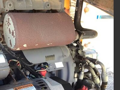 An industrial engine with rusted components and wiring, part of heavy machinery equipment.