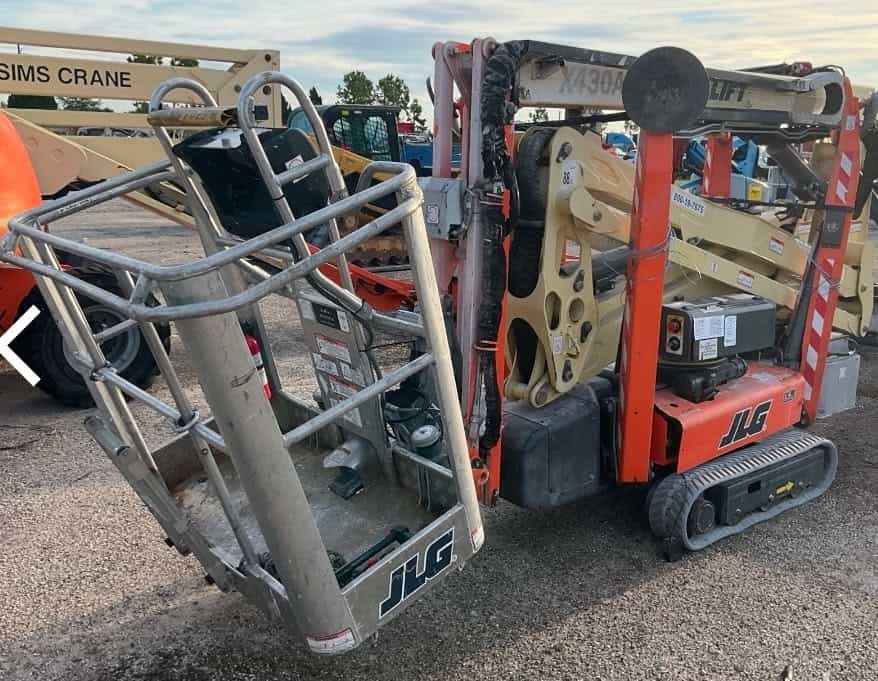 JLG 1930ES electric scissor lift, compact aerial work platform for indoor and outdoor use, in a construction yard.