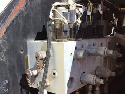 Close-up of hydraulic control valves on a heavy-duty construction machine, no identifiable year or model.
