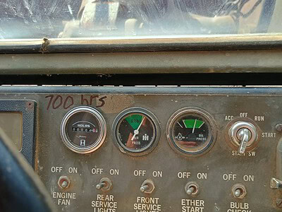 Vintage John Deere tractor dashboard with gauges and switches, circa 1970s.