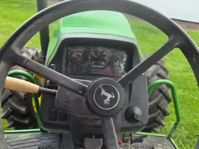 Green John Deere 5425 tractor dashboard with steering wheel and controls.