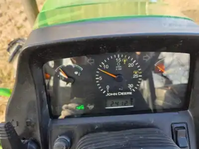 John Deere tractor dashboard with gauges and odometer, outdoor setting, close-up view.