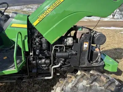 John Deere compact utility tractor with front loader, green color, outdoor setting.