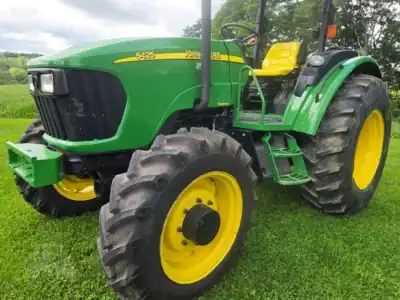 2007 John Deere 5425 tractor with green body and yellow wheels on grassy field.