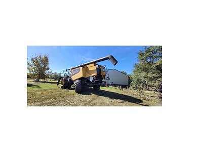 John Deere 2015 S690 combine harvester with grain tank and header attachment in a rural field setting.
