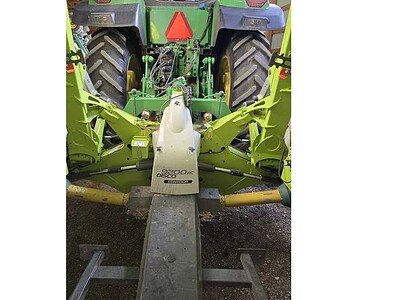 John Deere 8R Series tractor with front-mounted agricultural equipment, green and black color, large tires, and modern design.