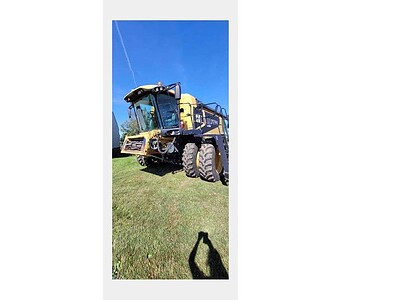 John Deere 644K wheel loader, yellow construction equipment, on grassy field with blue sky background.