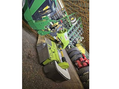 Green John Deere 2022 commercial mower with multiple attachments and large tires.