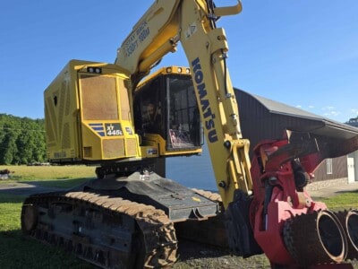 Komatsu PC45MR-5 mini excavator with yellow body and black tracks, working outdoors.