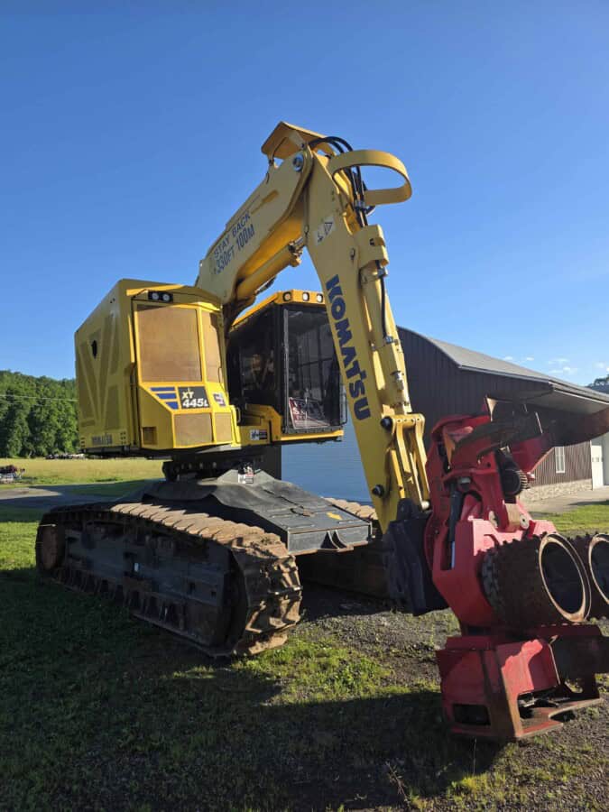 Komatsu PC45MR-5 mini excavator with yellow body and black tracks, working outdoors.