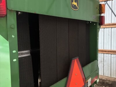 John Deere 458 green agricultural equipment with radiator and warning triangle.
