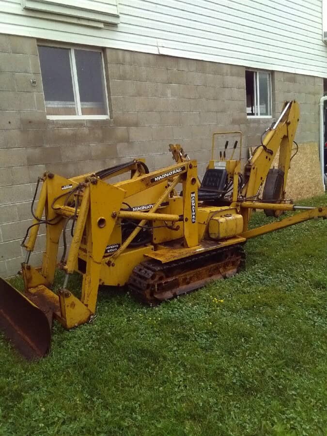 Yellow Mecalac 6MDX mini excavator with tracked undercarriage and hydraulic arm.